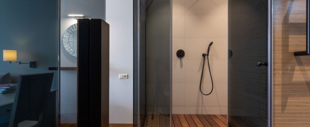 Drempelloze inloopdouche met glazen wanden en houten vloer